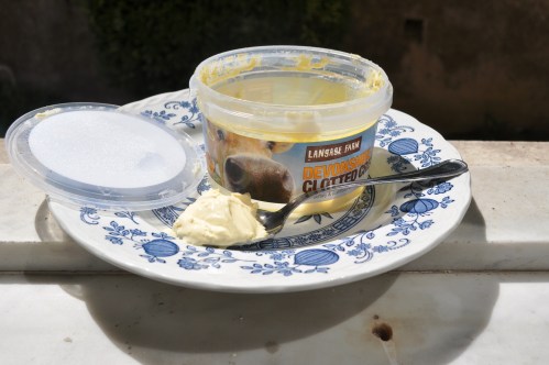 A large - nearly empty - ot of Langage clotted cream